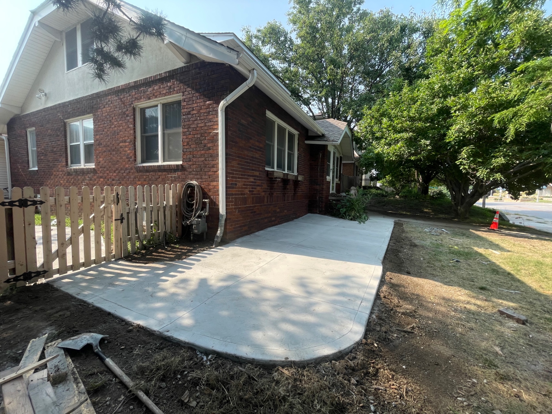 Concrete Patio Along Brick Home — Wide view